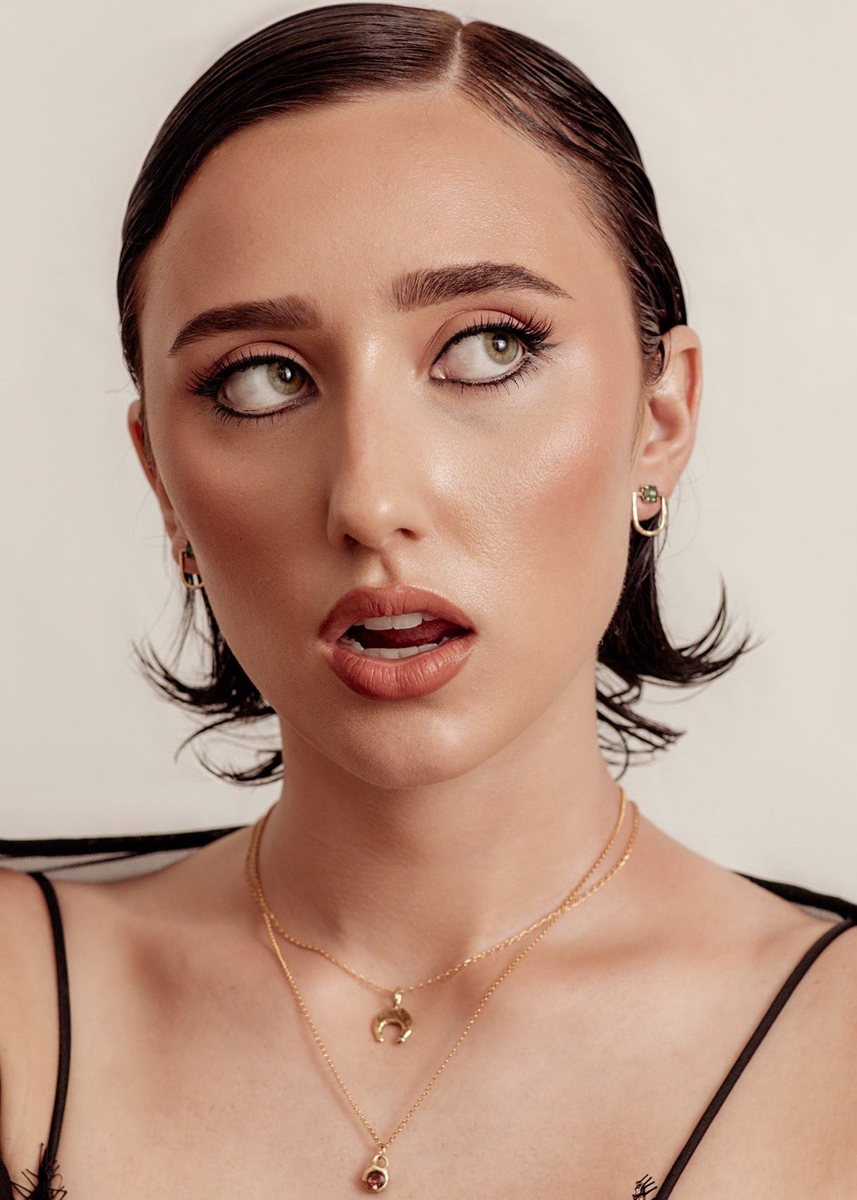 Woman wearing a black lace top against a neutral background