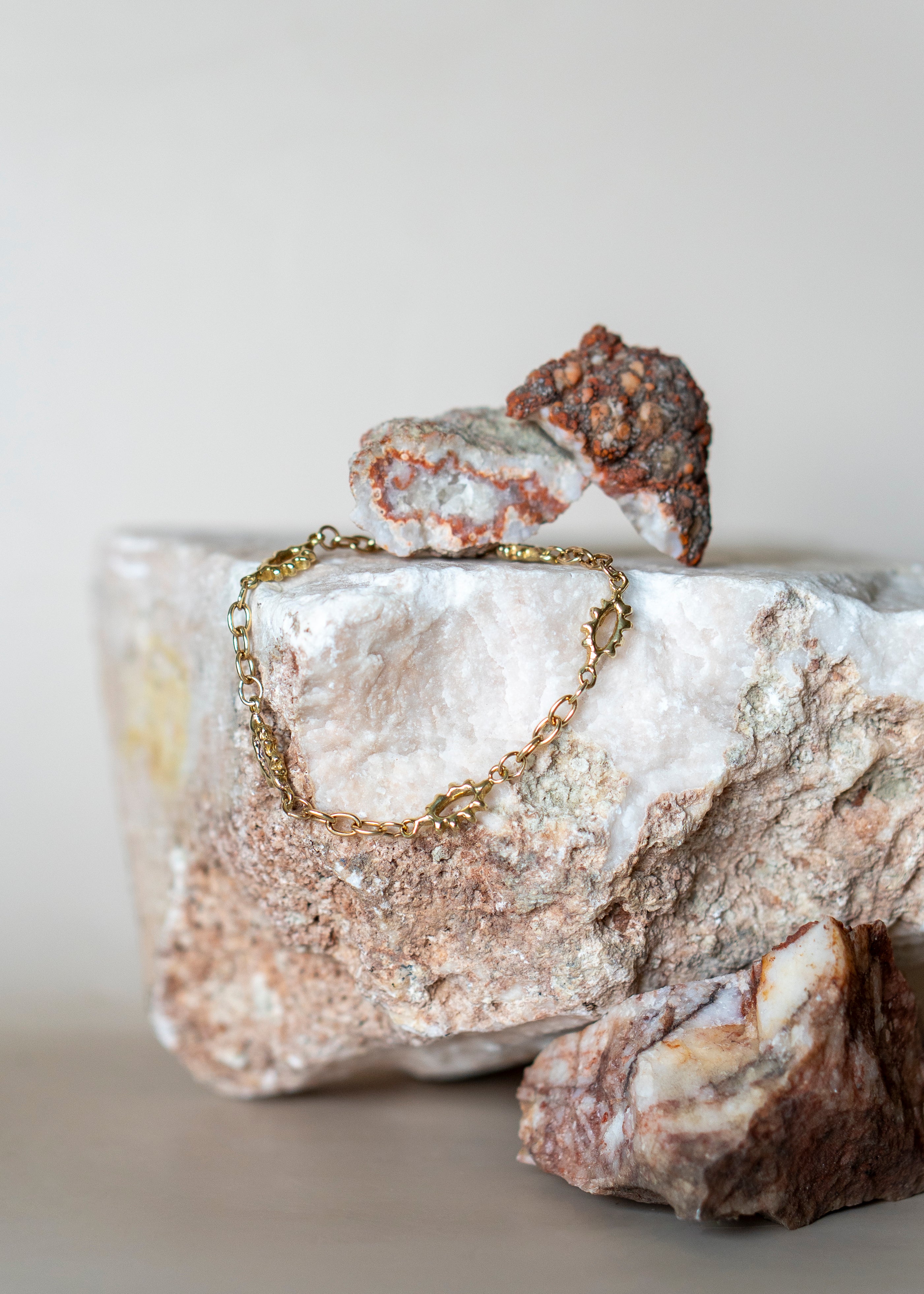 Helia Chain Bracelet draped over rock