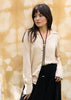 a black tether necklace against a textured beige background