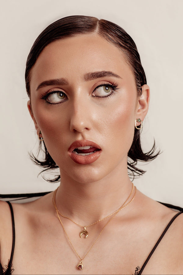 Woman wearing a black lace top against a neutral background