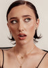 Woman wearing a black lace top against a neutral background