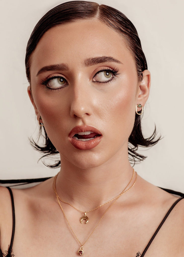 Woman wearing a black lace top against a neutral background