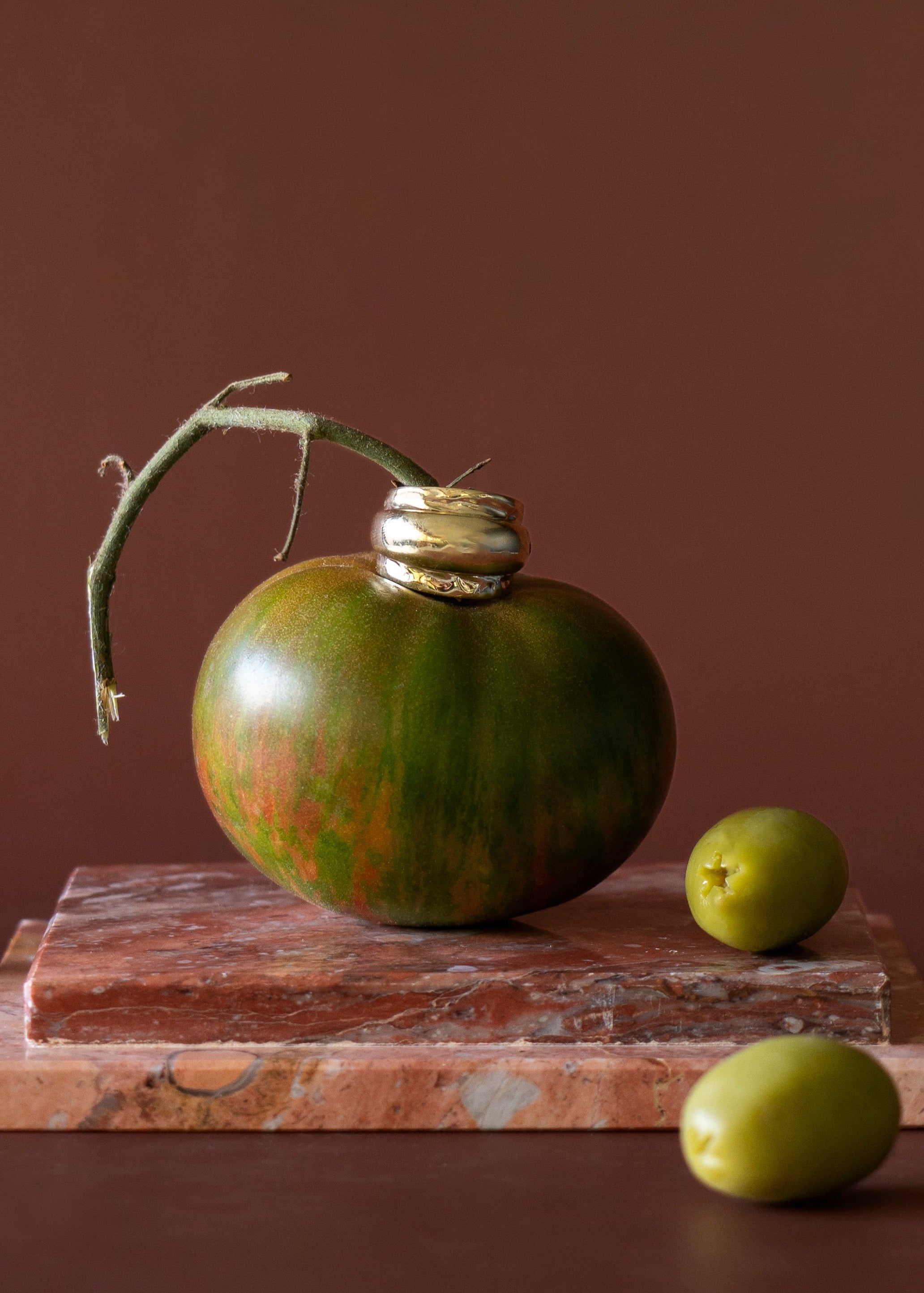 Sleek dome ring sitting on top of a green tomato
