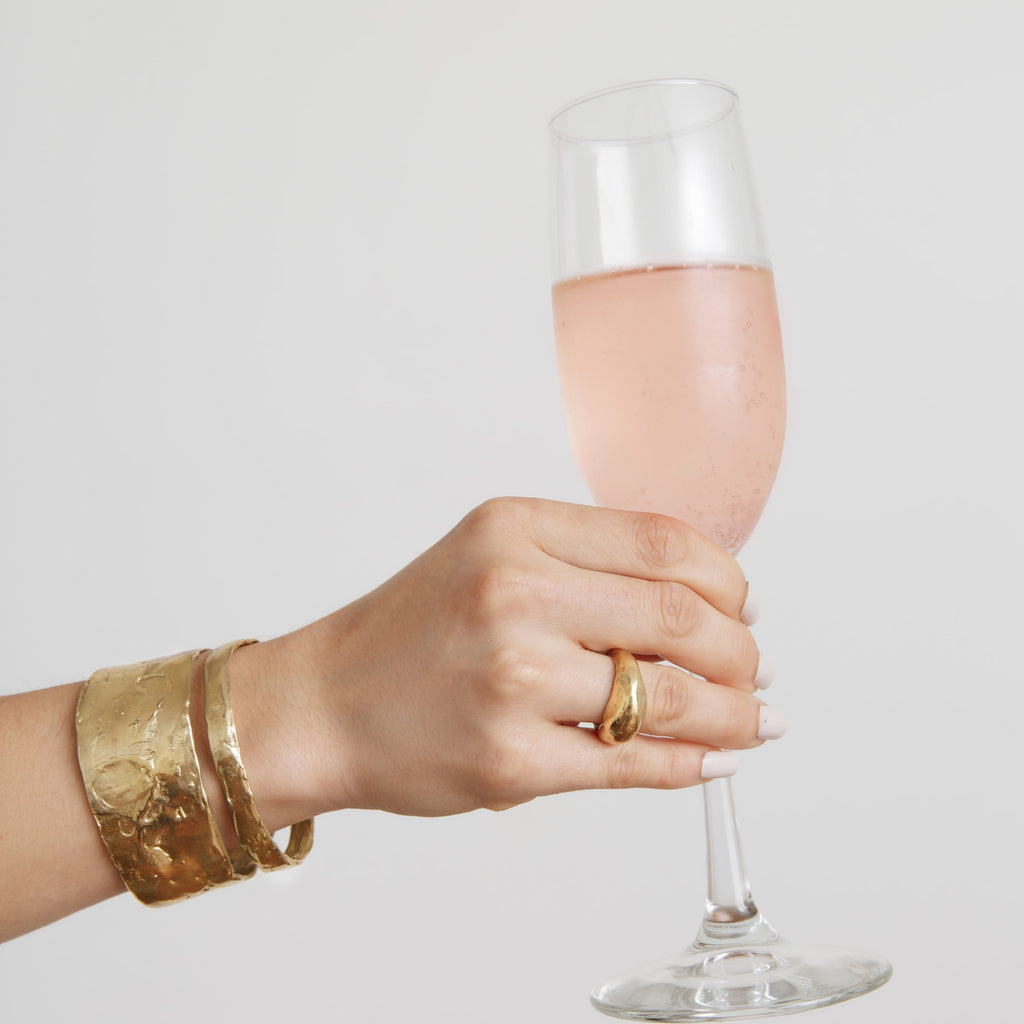 Dalles Cuff on arm holding champagne
